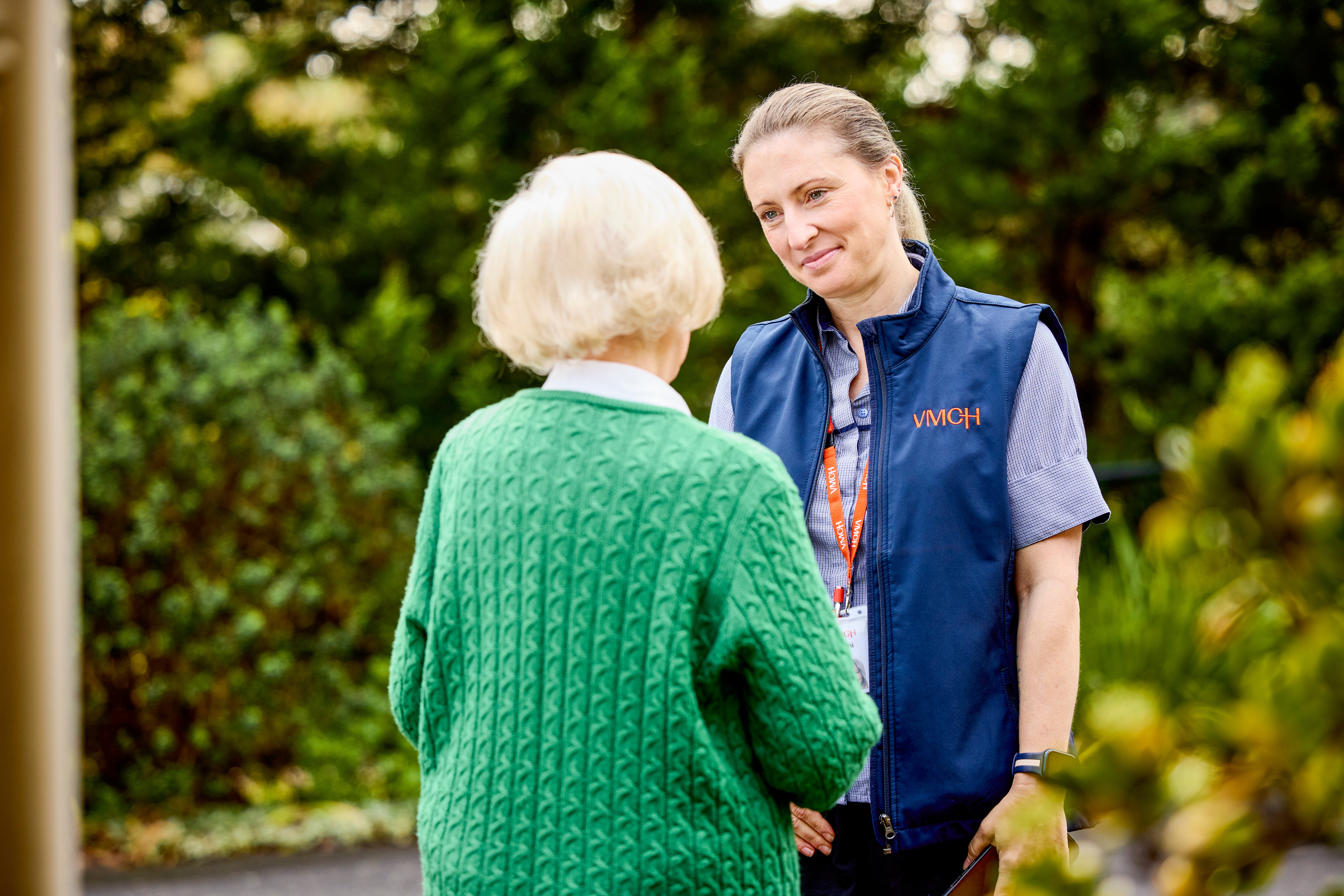 An older women speaking to another women wearing a uniform.