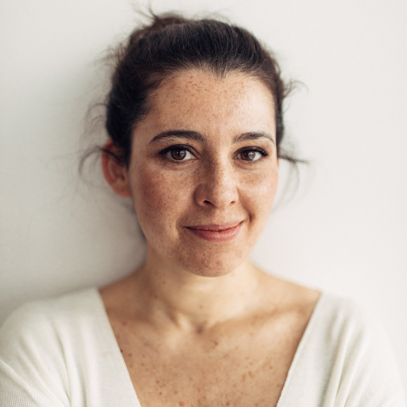 A portrait of a young woman with her hair pulled back.