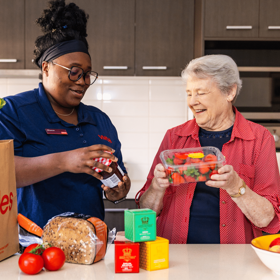 VMCH aged care staff member assisting a resident with groceries in the kitchen, fostering independence and daily living support.