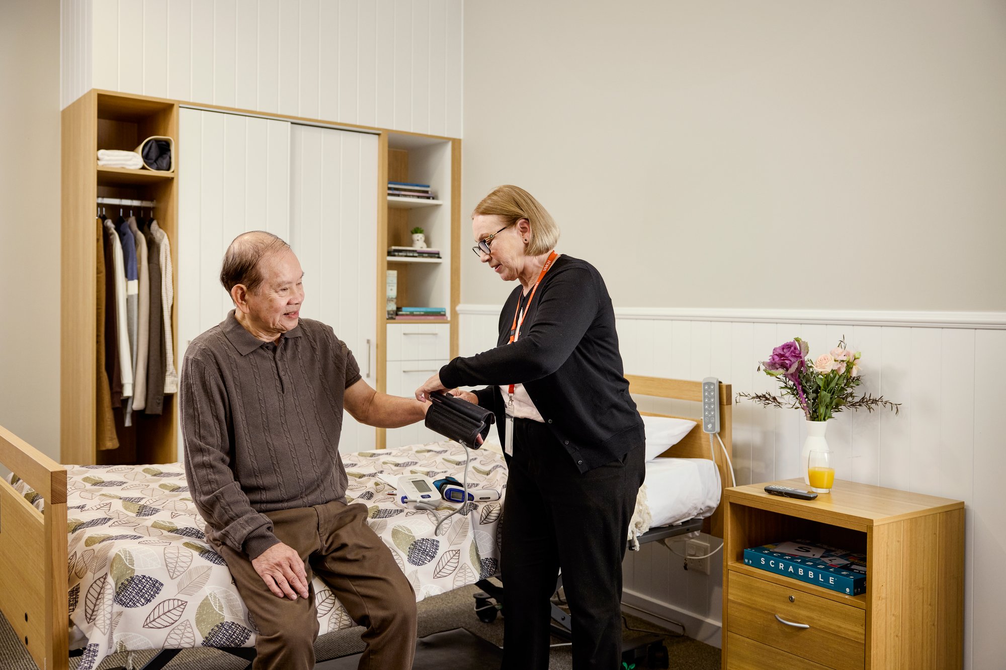 Aged care worker taking an elderly male's blood pressure